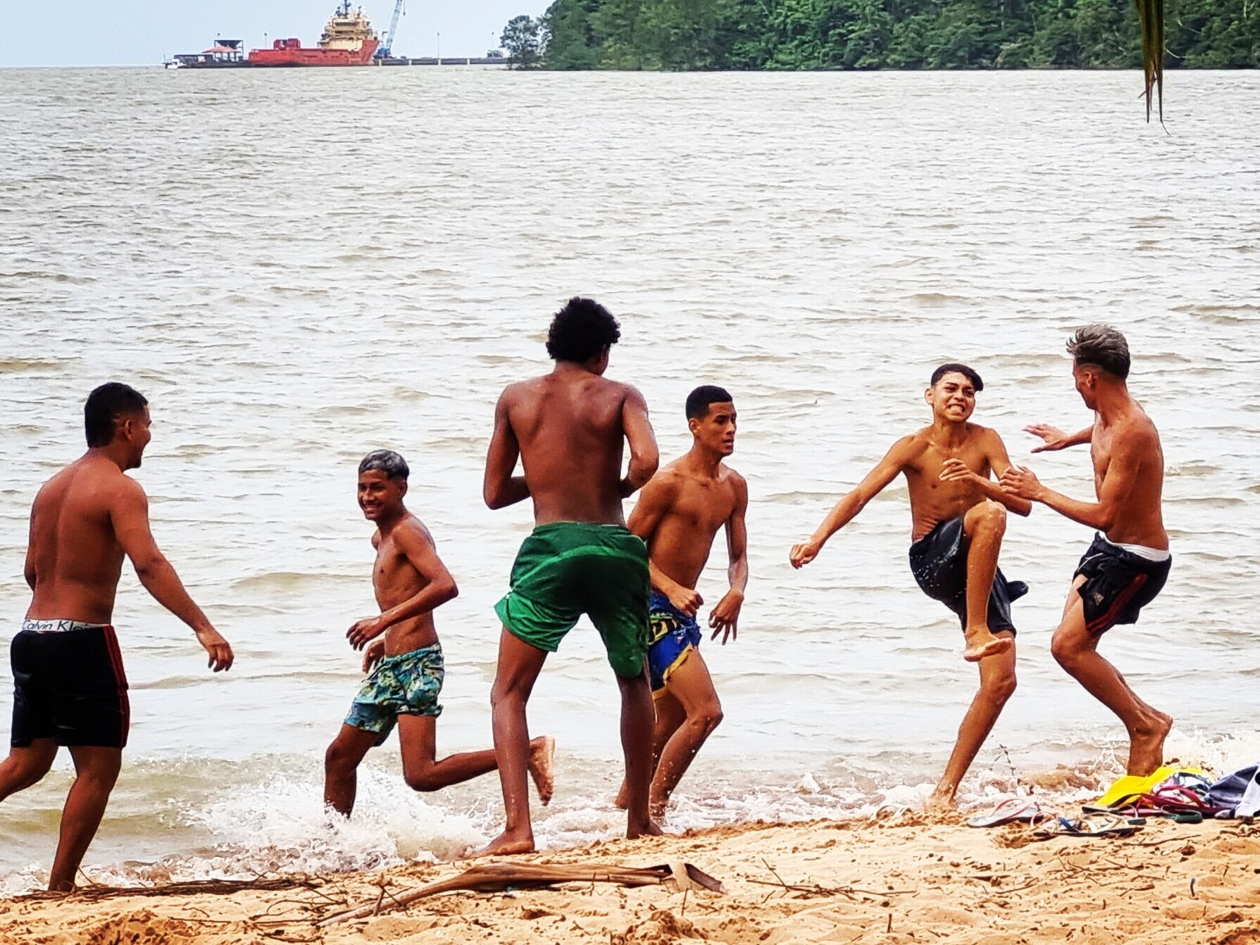 Adolescentes brincando na beira de um rio na amazonia